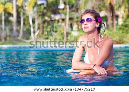 young beautiful woman in white bikini relaxing in spa pool