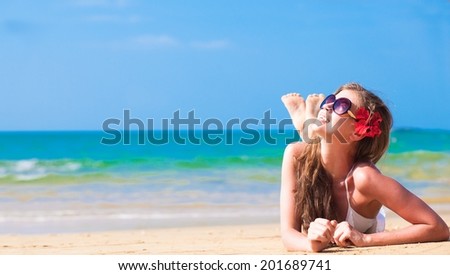 long haired woman in bikini with flower in hair on tropical beach
