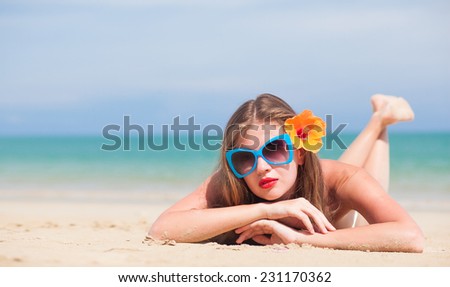 portrait of young beautiful woman with red lips and hibiscus blowing air kiss
