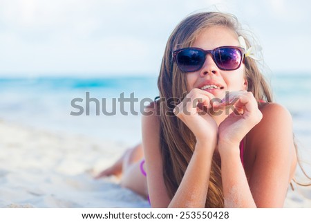long haired girl in bikini and with flower in hair on tropical barbados beach