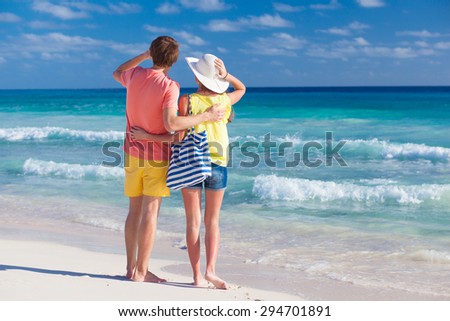 back view of happy romantic young couple pointing at the sky