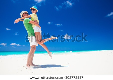 Couple in bright clothes having fun at tropical beach