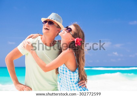 Romantic couple in bright clothes enjoying sunny day at tropical beach