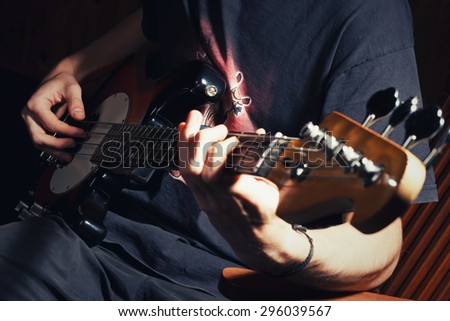 guy playing bass, guitar close-up