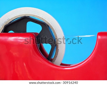 Sticky tape dispenser isolated against blue background