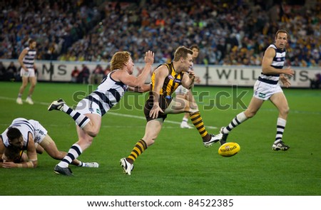 MELBOURNE - SEPTEMBER 9 : Sam Mitchell kicks under pressure from Cameron Ling in Geelong\'s win over Hawthorn - September 9, 2011 in Melbourne, Australia.