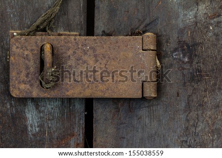 Closeup of old rusty door hinge on wooden door
