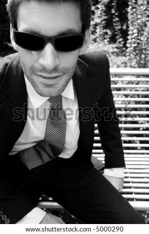 Cool business man with designer stubble wearing dark shades (focus in face)