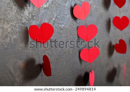 cute red hearts on the wall with texture.Serce paper on a rope