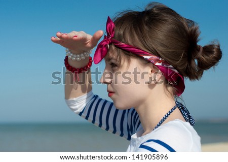 the beautiful girl at the sea looks afar close up