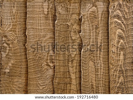 A close up section of rustic wooden garden fencing with vertical, overlapped panels.