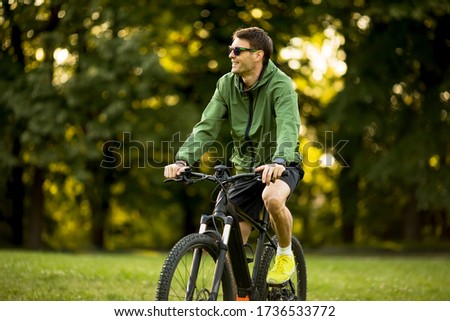 Similar – Image, Stock Photo Young man riding ebike in the park