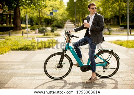 Similar – Image, Stock Photo Young man riding ebike in the park