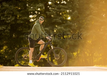 Image, Stock Photo Young man riding ebike in the park