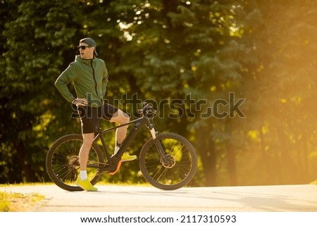 Similar – Image, Stock Photo Young man riding ebike in the park