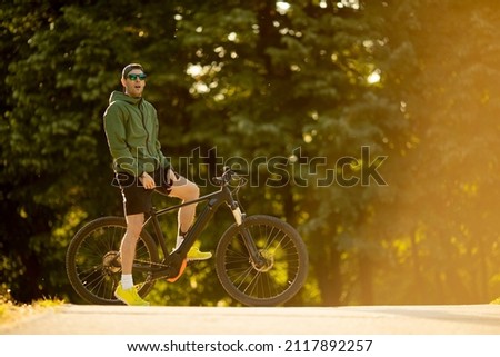 Similar – Image, Stock Photo Young man riding ebike in the park