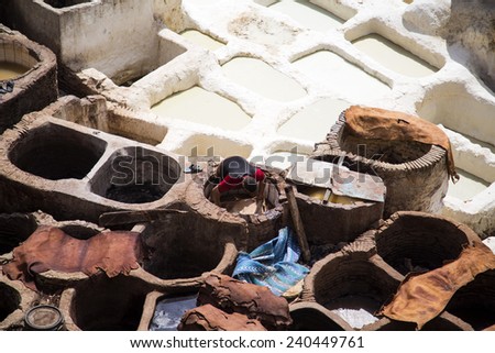 FES, MOROCCO - SEPTEMBER 15, 2014: Unidentified man working at tannery in Fes, Morocco. This is the oldest leather tannery in the world and has not changed since the 11th century.