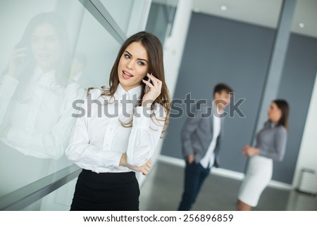 Young woman in office with mobile phone