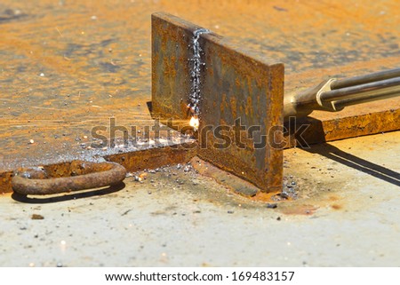 blow torch being used to cut through a thick piece of steel