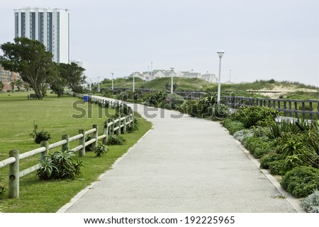 long path running along the beach front with buildings in the background