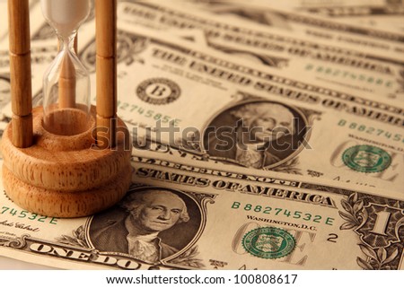 Sand passing through timer on American banknotes