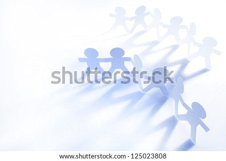 Two groups of paper chain people holding hands together