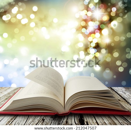 Open book on table in front of bright lights