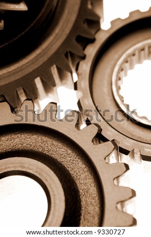 Three gears meshing together over white