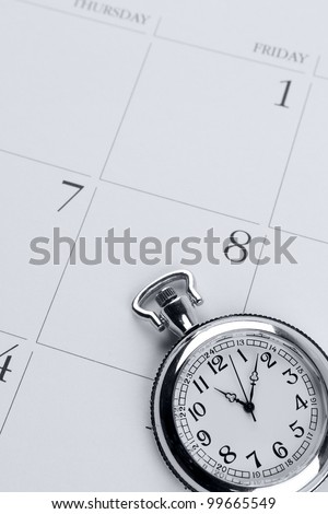 Pocket watch on calendar page