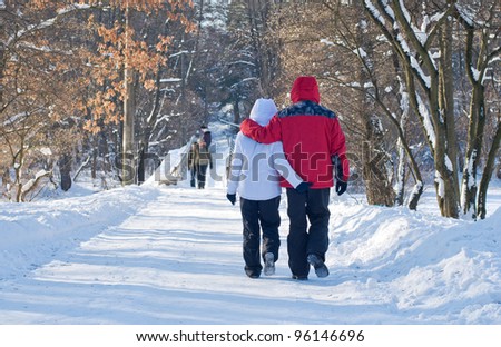 Men and women walking through winter park together