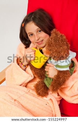 Little girl, caucasian, european, brown hair, blue eyes, dressed in a robe, sitting in an armchair with the flu, taking care of her teddy bear