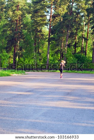 The young woman on morning jog in wood.