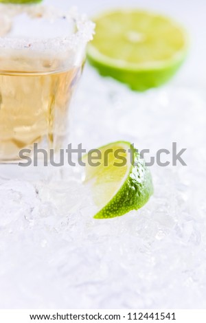gold tequila with salt and lime on a ice.