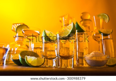 gold tequila , lime and salt on wooden table
