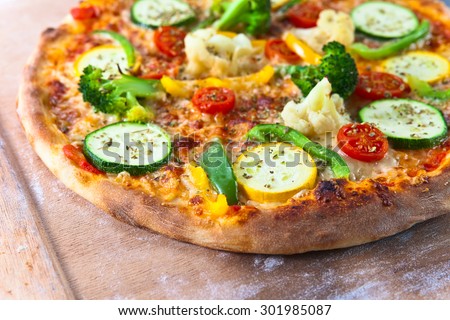 fresh baked vegan pizza on wooden shovel