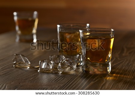 whiskey with ice in bar on old wooden table
