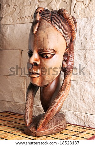 Ancient wooden sculpture from Africa on a sunlight. A head of the woman.