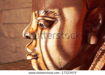 Ancient wooden sculpture from Africa on a sunlight.