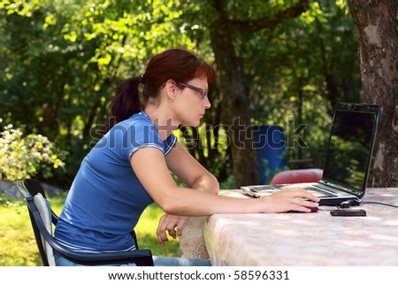 woman with laptop in garden.