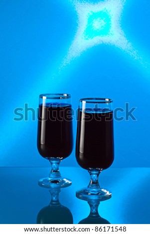 Cherry brandy on a glass table, a background is shined by the blue filter.