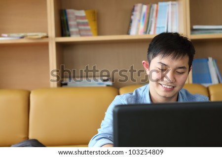 college student with laptop indoor and smiling