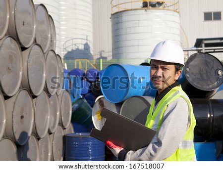 Portrait of a smiling confident supervisor stock  drum checking in warehouse