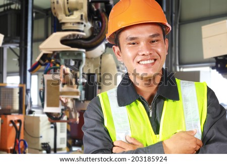 Close up man factory engineer or worker with robot machine inside modern industrial manufacturing, automobile industry