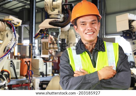 Man factory engineer or worker with robot machine inside modern industrial manufacturing, automobile industry