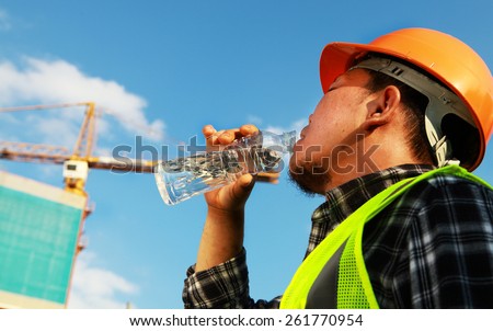 Construction worker drinking water on a location site