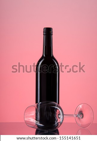 image of bottle with red wine and glass on a red gradient