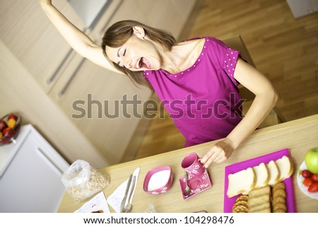attractive skinny woman yawns while drinking coffee