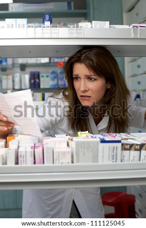 Beautiful woman pharmacist looking for medicine worried