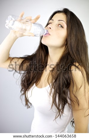 Gorgeous female model drinking water from bottle thirsty