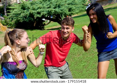 Handsome man having fun about two girls ready to cat fight for him